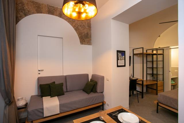 San Nicola Room: living area with sofa and tuff arch